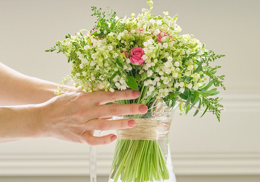 A cheerful bouquet of white flowers radiates beside a bedroom window